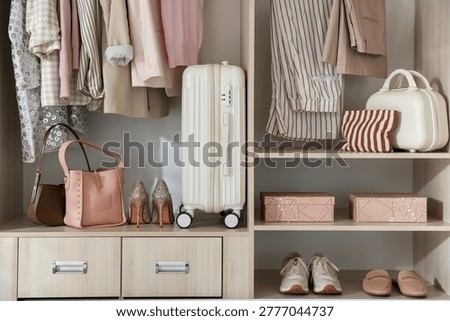 Wardrobe with different neatly organized clothes and home stuff