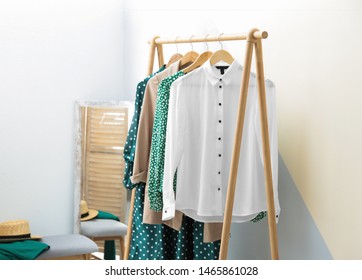 Wardrobe Rack With Women's Clothes At Color Wall In Room