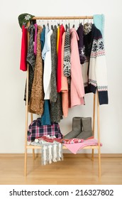 Wardrobe With Winter Clothes Nicely Arranged. Dressing Closet With Colorful Clothes And Accessories On Hangers.