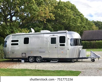 Wareham, Dorset, United Kingdom. 5th October 2017. Iconic luxury American Airstream caravan parked on gravel on a campsite in Wareham, Dorset UK with trees to the rear.