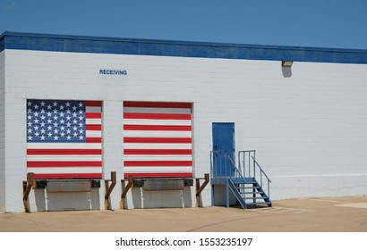 Warehouse with american flag painted receiving docks / Logistics building with entrance door and white and blue brick wall with copy space