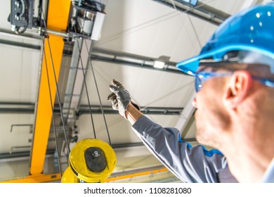 Warehouse Ceiling Mounted Crane Lift Operator Explaining How the Machine Works. Industrial Technologies. - Powered by Shutterstock