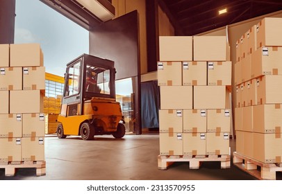 Warehouse center. Pallets with boxes in building. Forklift inside storage hangar. Cardboard parcels on boxes. Warehouse area. Forklift is loading. Delivery service warehouse. Logistics processes