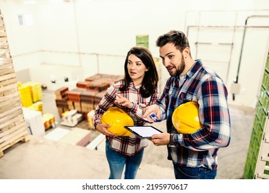 The Warehouse Employees Holding Tablet With Checklist And Talking About Job Improvement.