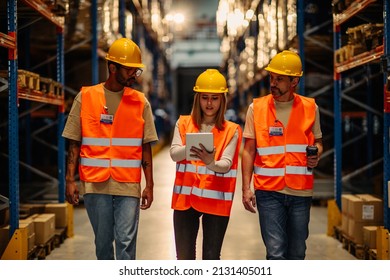 Warehouse Employees Walking Through Aisle And Talking