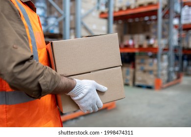 Warehouse Engineer In Workwear Carrying Boxes With Goods