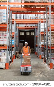 Warehouse Engineer In Workwear Moving Forwards Between Racks