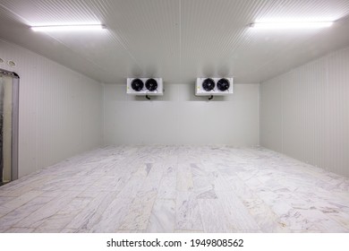 Warehouse Freezer, Cold Storage. Refrigeration Chamber For Food Storage. An Empty Industrial Room Refrigerator With Four Fans.