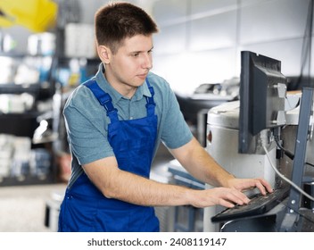 Warehouse guy employee looks at computer monitor screen and checks completeness of order for customer. Female worker of paint shop reads customers input data on computer