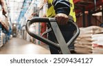 Warehouse, hand and worker pull pallet truck for supply chain, restock or moving freight. Factory, person and trolley for cargo storage, distribution logistics and back in shipping industry closeup