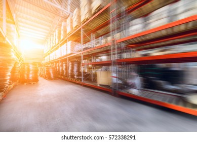 Warehouse industrial and logistics companies. Commercial warehouse. Boxes and crates stocked on the shelves of three storey. The effect of motion blur. Bright sunlight.
