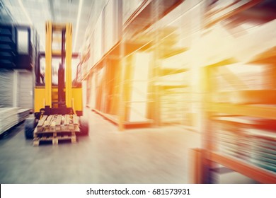 Warehouse industrial premises for storing materials and wood, there is a forklift for containers. Concept logistics, transport. Motion blur effect. Bright sunlight. - Powered by Shutterstock