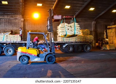 Warehouse Intake, Forklift Carrying Sugar Bags From Truck To Stack Inside A Warehouse. Sugar, Grain, Food, Rice, Maize, Cargo In Bags Handling Concept.