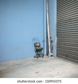 Warehouse Interior Corner With Broken Office Chair Held Together With Gaffer Tape.