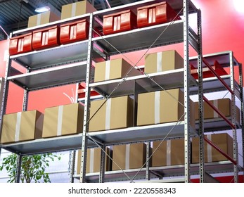 Warehouse interior. Metal storage racks close-up. Boxes on warehouse racks. Warehouse steel furniture. Multi-tiered shelving for safekeeping. Boxes made of cardboard and plastic on far rack - Shutterstock ID 2220558343