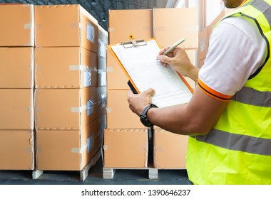 Warehouse inventory management. courier shipment transportation. Stack of cardboard boxes on wooden pallet.  warehouse worker is writing on clipboard with inspecting the shipment.  - Powered by Shutterstock