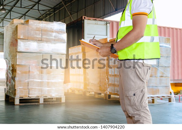 warehouse inventory management, freight\
transportation. warehouse worker in uniform is inspecting order\
shipment load into a\
truck.