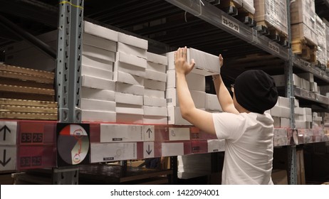 Warehouse Large Storage Or Cargo For Distribution And Man Is Picking Up A Box.