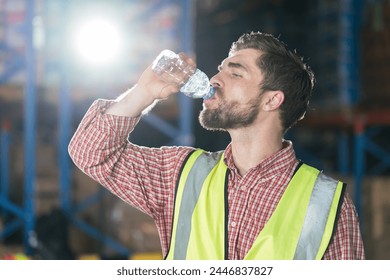 Warehouse male worker drinking water in break time in warehouse storage. Male worker drinking water in warehouse - Powered by Shutterstock