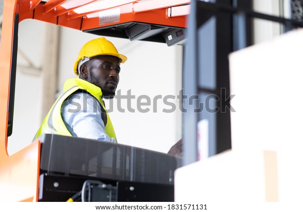 Warehouse man worker driver forklift. warehouse
worker driver stacking card boxes by forklift in warehouse store.
African American black
people.