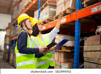 Warehouse Management Team Checking Organization And Distribution In Storage Shipping Center.manager Is Showing A Clipboard To A Worker In A Warehouse