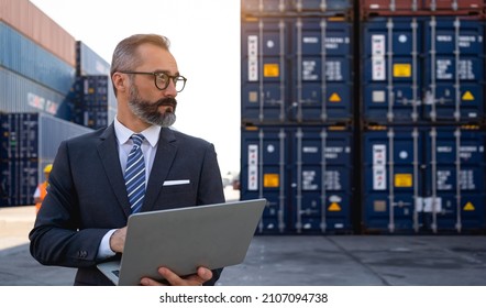 The warehouse manager or business man are using laptops view oranalytics warehouse information. He used technology to help with warehouse management at shipyards in transportation logistic concept. - Shutterstock ID 2107094738