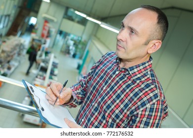 warehouse manager checking inventory in a large warehouse