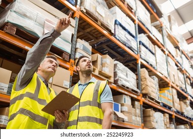 Warehouse Manager And Foreman Working Together In A Large Warehouse