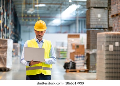 Warehouse manager with laptop entering inventory data to database - Powered by Shutterstock