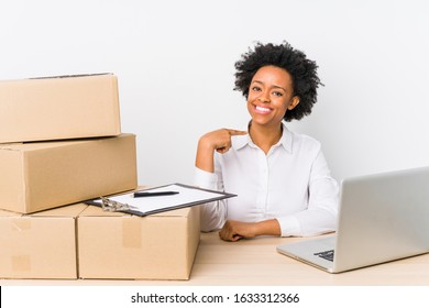 Warehouse manager sitting checking deliveries with laptop person pointing by hand to a shirt copy space, proud and confident - Powered by Shutterstock