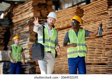 Warehouse Manager Talking To African American Worker While Walking Through  Lumber Distribution Department..