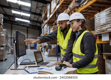 Warehouse manager talking with logistics employee in warehouse, planning transport of products, talking shipping process. - Powered by Shutterstock