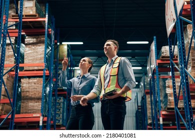 Warehouse manager talking and using digital tablet while checking product in warehouse, Logistic industry concept.