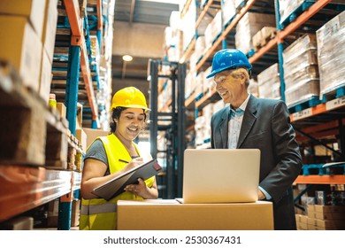 Warehouse manager and worker discussing inventory on laptop - Powered by Shutterstock