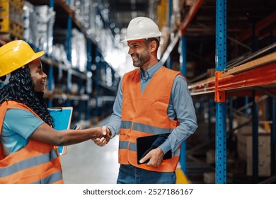 Warehouse manager and a warehouse worker shaking hands after reaching an agreement during a working day at the warehouse - Powered by Shutterstock