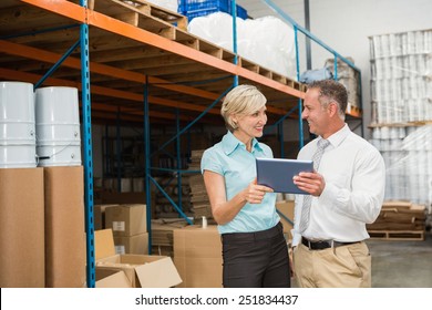 Warehouse managers using tablet pc in a large warehouse