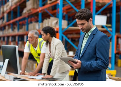 Warehouse Managers And Worker Working Together In Warehouse Office