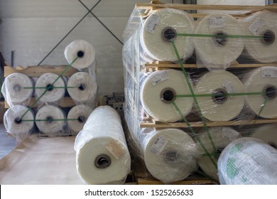 Warehouse with new plastic wrap rolls stretch packed on pallets for polycarbonate production