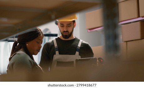 Warehouse operation executives perform inventory control, keeping quality standards high, knowledgeable experts in storage deposit prepare to ship parcels, crosschecking delivery info.