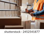 Warehouse operative checking a document on a clipboard and preparing a shipment