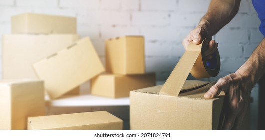 Warehouse Order Picker Packing And Sealing Cardboard Box With Tape For Dispatch