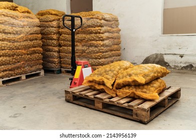 warehouse with potatoes. potatoes in sacks loaded onto a pallet truck. potato harvest - Powered by Shutterstock