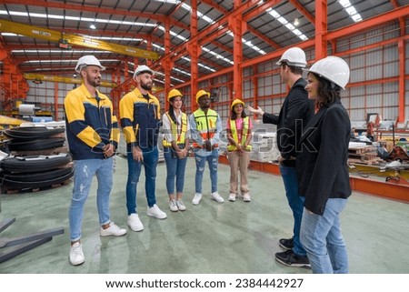 Warehouse safety meeting, people with hardhat. Industrial teamwork.
