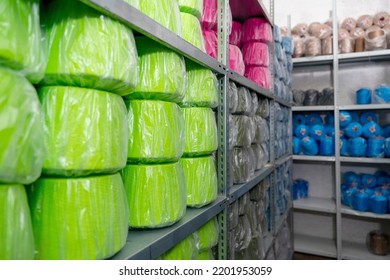 Warehouse with skeins of colored threads on shelves of high racks. shelf of haberdashery with lots of threads, yarn. Repository textile factory, garment wholesale trade store for sewing.  - Shutterstock ID 2201953059