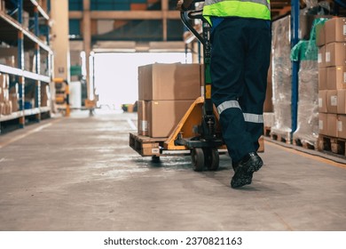 Warehouse staff moving load parcel box with Hand pallet truck or Hand lift manual delivery shipping goods in shelf storage area. - Powered by Shutterstock