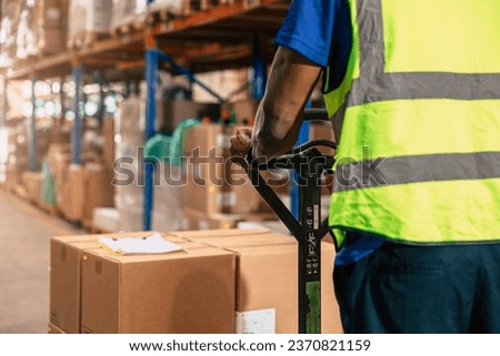 Warehouse staff moving load parcel box with Hand pallet truck or Hand lift manual delivery shipping goods in shelf storage area.