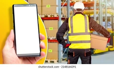 Warehouse And Storage App On Smartphone. Storekeeper With Box Is Standing With His Back. Mobile Phone With Blank Screen On The Background Of The Warehouse. Goods And Boxes On Storehouse Shelves.