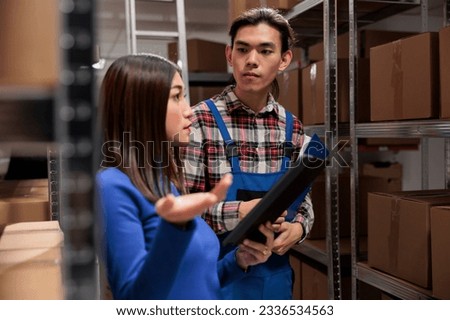 Warehouse supervisor explaining parcel storing quality control to coworker. Storehouse employees doing order fulfillment while using inventory management software digital tablet