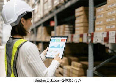 Warehouse Supervisor in safety suite using digital tablets to check the stock inventory on shelves in large warehouses, a Smart warehouse management system, logistic network technology concept. - Powered by Shutterstock