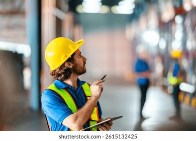 Warehouse supervisor wearing using a digital device to manage operations while standing in storage area. The integration of digital technology in modern warehouse operations and inventory management